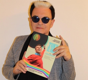 Cristiano Malgioglio che mostra la copertina del libro