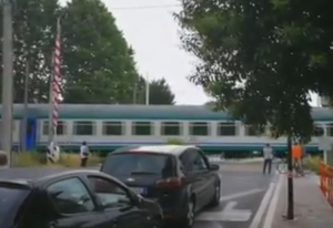 Sambuceto. Passa il treno, al passaggio a livello sbarra aperta.