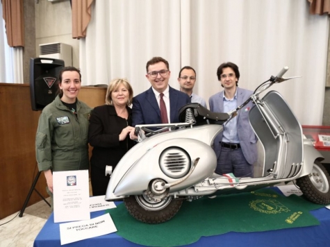 Antonio Blasioli con gli ospiti della mostra e la vespa