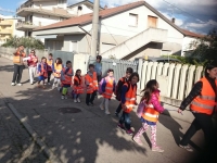 Una mamma che con il sorriso sulle labbra accompagna i bambini a scuola